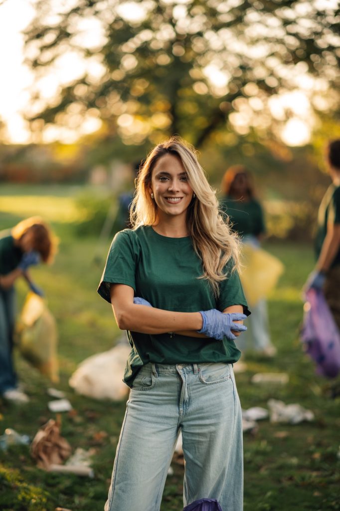 Young woman volunteering collecting trash in park